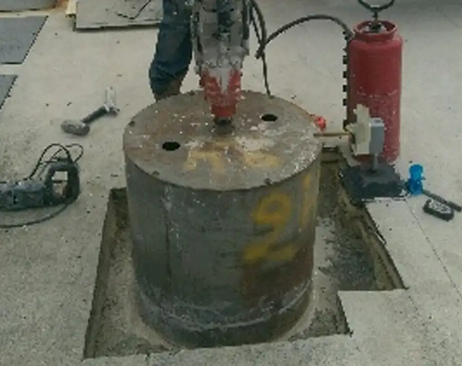 A core drill pulling a large core sample marked 16 from a concrete slab
